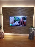 Realizace podsvíceného dřevěného obkladu v obýváku za televizí