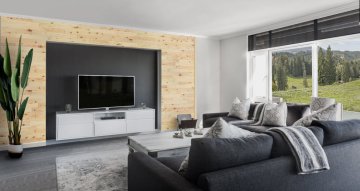 Realizace dřevěného obkladu z borovice v obýváku kolem televize